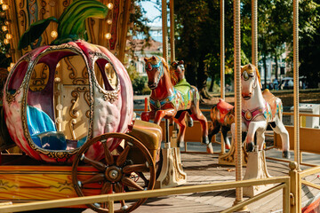 Colorful carousel horses and a decorative carriage stand in Kalemegdan Park in Belgrade. The scene suits travel, leisure, childhood and family entertainment themes. © Ekaterina