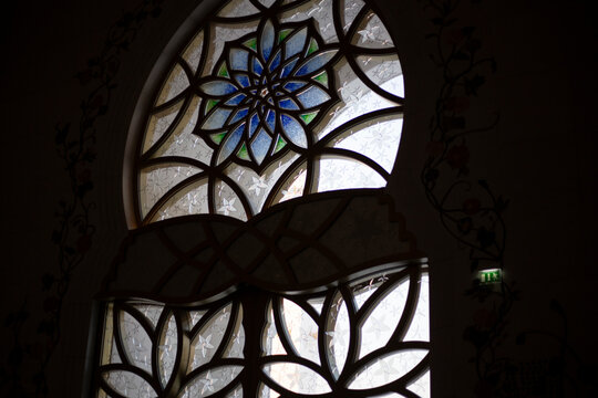 Stained glass detail on the beautiful Grand Mosque building in Abu Dhabi with beautiful flower shape patterns and geometric textures