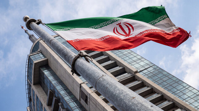 Iranian National Flag Waving on Metal Flagpole Against Modern Building