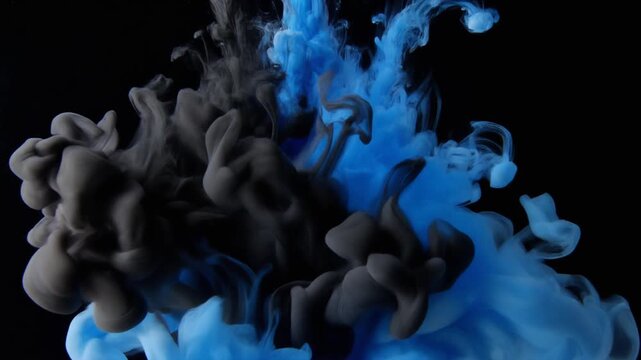 Dynamic explosion of black and vibrant blue ink swirling in water creating abstract artistic patterns