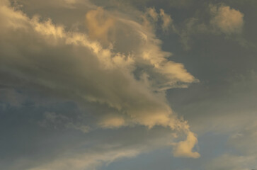 Obraz premium Scenic landscape photography of a dynamic sunlit cloud formation against a moody twilight sky