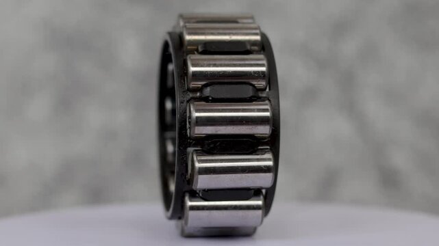 Static shot of Single row cylindrical roller bearing assembly rotating on display stand in workshop.