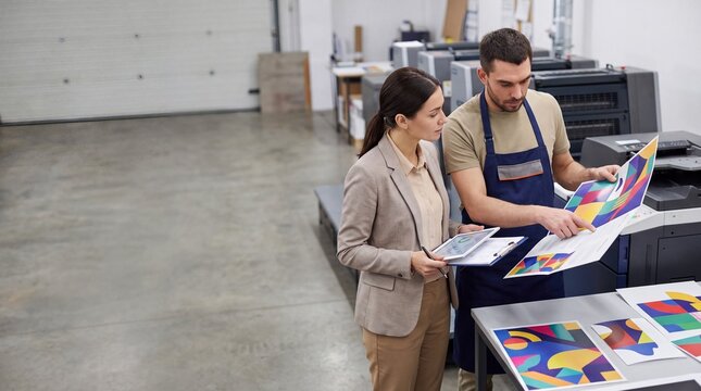 Professional and client evaluating color proof in print shop