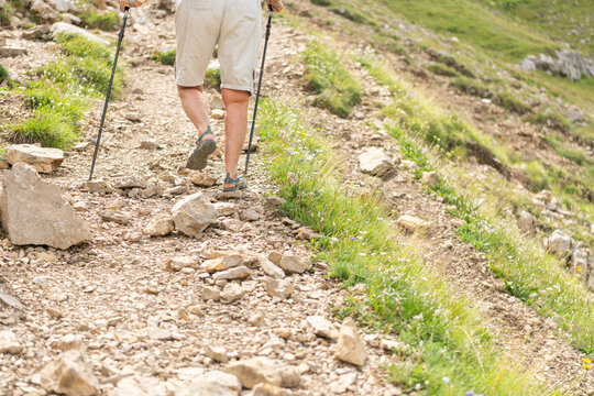 Selva di Cadore, Italy. Hiker using trekking poles on a rocky alpine trail in the Dolomites