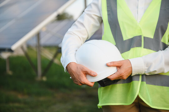 Engineer worker holding hard hat at solar farm