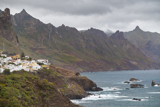 The Anaga Rural Park, with the sharp peaks of the mountains shrouded in mist and clouds, and the houses from above in Tenerife
