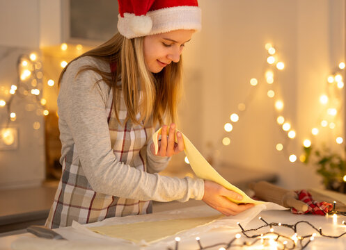 Teen Girl In A Santa Hat Making Christmas Cookies In The Kitchen