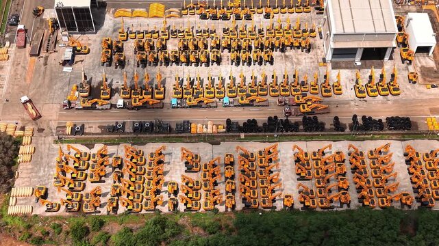 Yellow construction cranes lined up for dispatch at heavy equipment manufacturing plant industrial