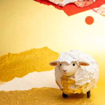 Torn washi paper craft sheep on golden landscape, handmade style Japanese New Year art