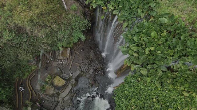 Stunning Aerial View of a Serene Waterfall Surrounded by Lush Green Vegetation in Nature's Embrace