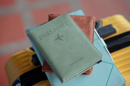 Travel passport holder and wallet placed on a stylish yellow suitcase, representing international travel, vacation planning, tourism, and holiday essentials.