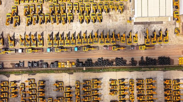 Rows of yellow construction cranes and heavy machinery at heavy equipment manufacturing unit industrial yard