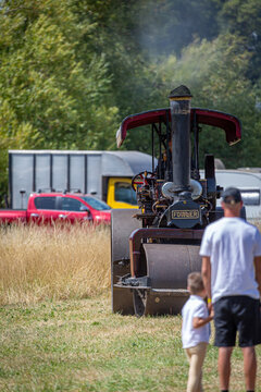 Vintage Fowler Steam Road Roller Operating at a Traditional British Country Show With Spectators Watching