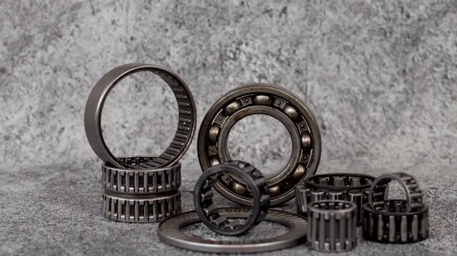 Panning shot of Assorted roller and ball bearings collection arranged on table in maintenance workshop.