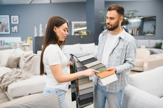 Young couple choosing fabric samples in furniture store