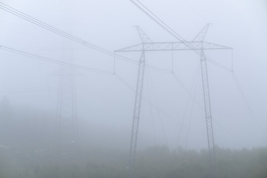 Power grid masts in thick fog