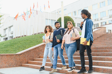 Obraz premium Diverse students walking down university stairs with books