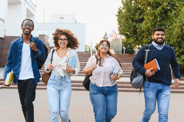 Diverse students walking on university campus smiling
