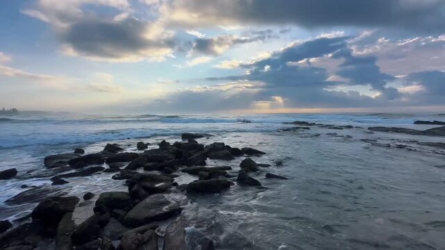sunrise over the sea, waves crashing over rocks, 