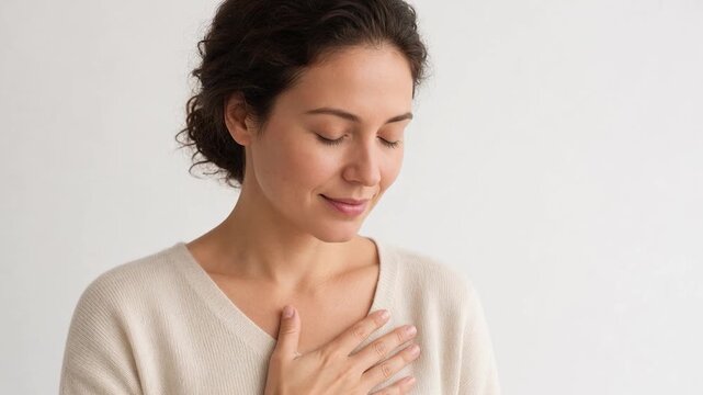 Grateful woman feeling thankful and blessed, holding hand on chest with eyes closed isolated on white background