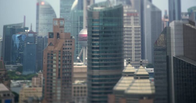 Modern Shanghai skyscrapers and the Oriental Pearl Tower stand across Pudong financial district in daytime, recorded in tilt shift miniature timelapse