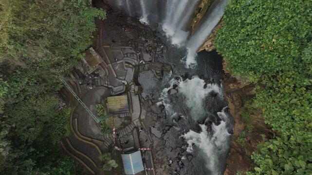 Spectacular View of a Magnificent Waterfall Surrounded by Lush Greenery and Rocky Terrain