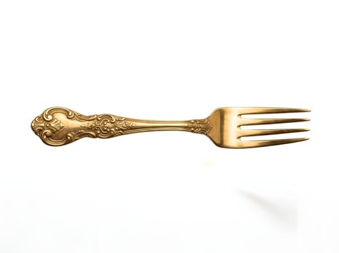 Ornate vintage gold fork isolated on white background