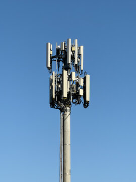 Cellular Telecommunications Tower with Multiple Antennas Against a Clear Blue Sky