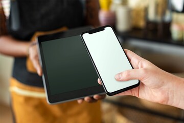 Hand holding smartphone and tablet with blank screens © Rawpixel.com