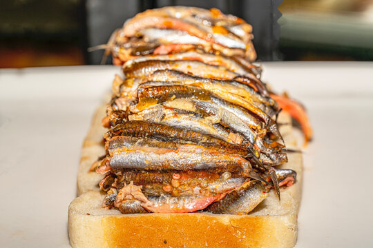 Traditional Turkish meze Hamsi Marin, marinated white anchovy fillets in olive oil and herbs on a plate.