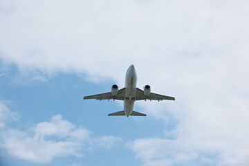 Fototapeta premium Commercial Passenger Airplane Climbing High After Takeoff Against Blue Sky