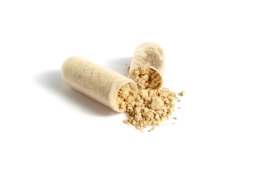 On a white background lies one capsule of medicine, open and with scattered powder.