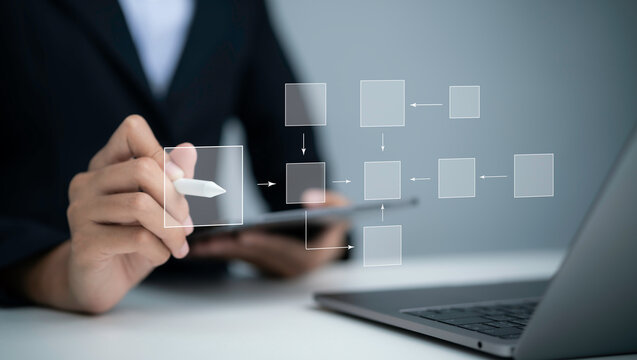 Business professional designing digital workflow diagram with process blocks and arrows using stylus and tablet for planning strategy automation process management and digital transformation