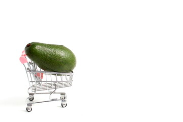 A miniature cart with avocados stands on a white background. ©  DENIS  