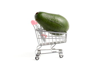 A miniature cart with avocados stands on a white background. ©  DENIS  