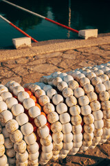 Stored swimming lane buoy ropes at an outdoor sea pool in Kvarner Bay, Croatia. Concept of sports equipment, swimming training, and poolside prep.