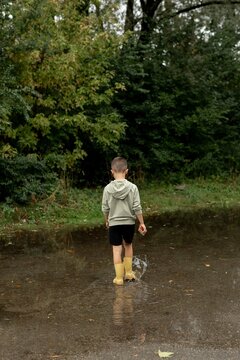 Child Playing in a Puddle Outdoors