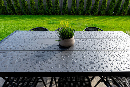 Composite wood garden table covered in refreshing water drops