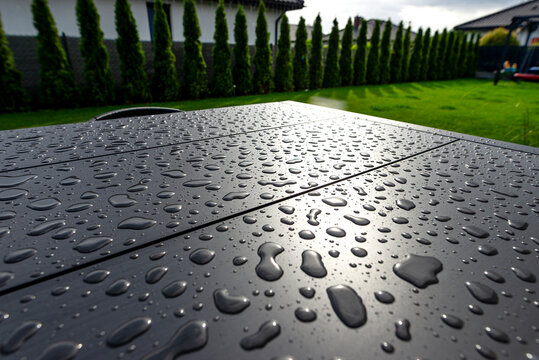 Garden table surface with water drops reflecting sun