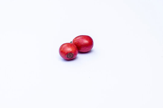 Liberica coffee (Coffea Liberica) on a white background, raw coffee. Large red Liberica coffee.