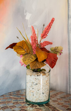 Arreglo floral oto&ntilde;al decorativo en florero de vidrio con hojas secas, flores y piedras blancas