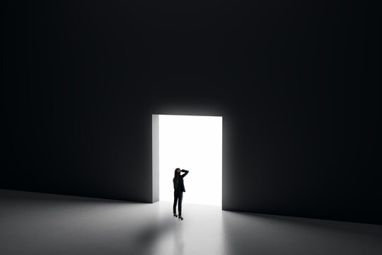 Businesswoman Seeking Opportunity Through a Bright Exit Door in a Dark Space, Symbolizing Hope, Direction, and New Paths for Business Growth.