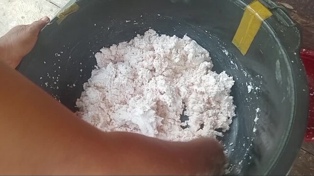 Close up of hands mixing sago flour and grated coconut dough for traditional recipe