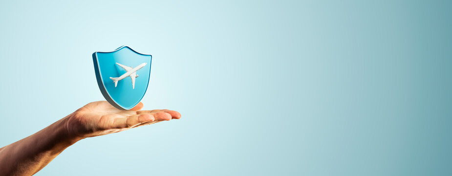 Travel protection concept with airplane shield held in hand for safe flight, business journey, tourism, vacation and airline security copy space.