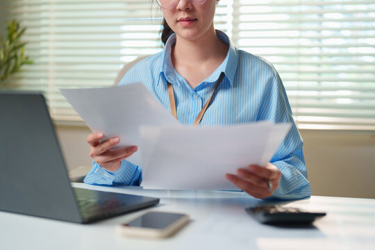 Business manager analyzing invoices, expense reports, and balance sheets at a clean workstation, cloud accounting platforms, SME cash flow management, and banking advisory collateral