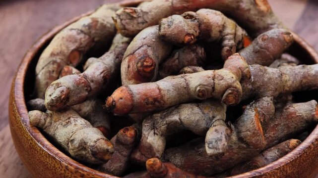 Fresh Turmeric Rhizomes in a Wooden Bowl