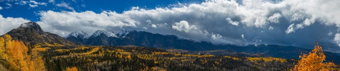 Aspen valley panorama in autumn with storm clouds over the mountains