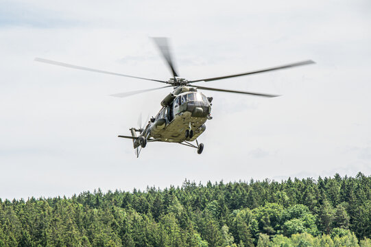 Military Helicopter in Flight above Trees 