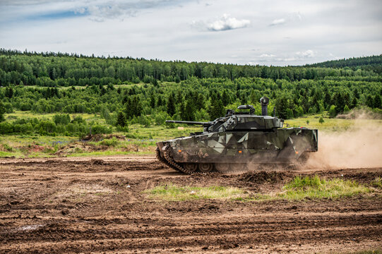 Camouflaged Tank Driving through Dust