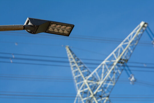 Eine Stra&szlig;enlampe vor einem Starkstrommast